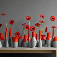 Red flowers in colored bottles