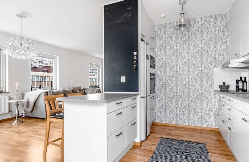 Paper wallpaper on the wall of the working area of the kitchen-living room